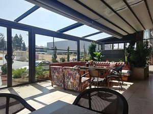 Seven Roses Hotel in Amman, image may contain: Terrace, Chair, Dining Table, Table