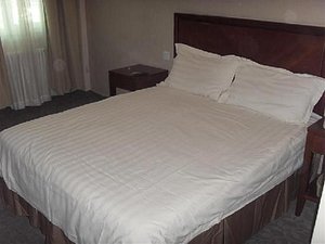 Home Inn Beijing Chaoyang North Road in Beijing, image may contain: Furniture, Bed, Bedroom, Room