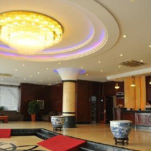 Gongshang Hotel in Dalian, image may contain: Foyer, Indoors, Plant, Person