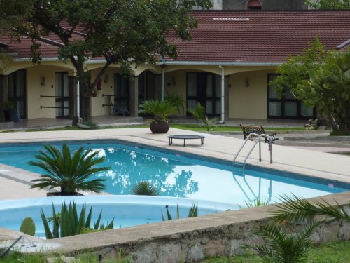 la piscine et les chambres en fond.