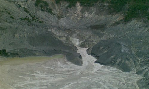 The crater of Tangkuban Parahu Mountain with sulphuric smoke out of its surface