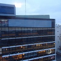Frente,10 pisos,paneles de vidrio.
