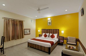 DIDI Hotel Alambagh in Lucknow, image may contain: Bed, Furniture, Ceiling Fan, Bedroom
