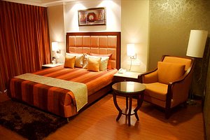 The Golden Plaza Hotel & Spa in Zirakpur, image may contain: Lighting, Furniture, Chair, Bedroom