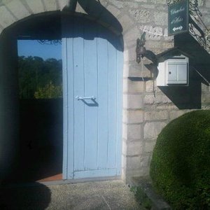 Entrée de la maison, derrière la porte entrouverte beau paysage de verdure en contrebas
