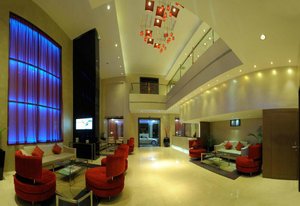 Hotel CAG Pride in Coimbatore, image may contain: Living Room, Lighting, Couch, Monitor