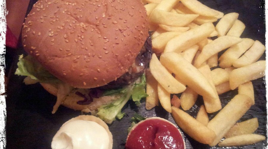 Ein stattlicher Burger mit köstlichen Fries und Saucen an der Seite (statt oben drauf)