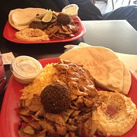2 meat lunch special, foreground both types of chicken w hummus & tahini, other plate = steak &