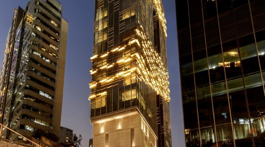 The glass-bottomed, cantilevered pool on the roof top shimmers at night.