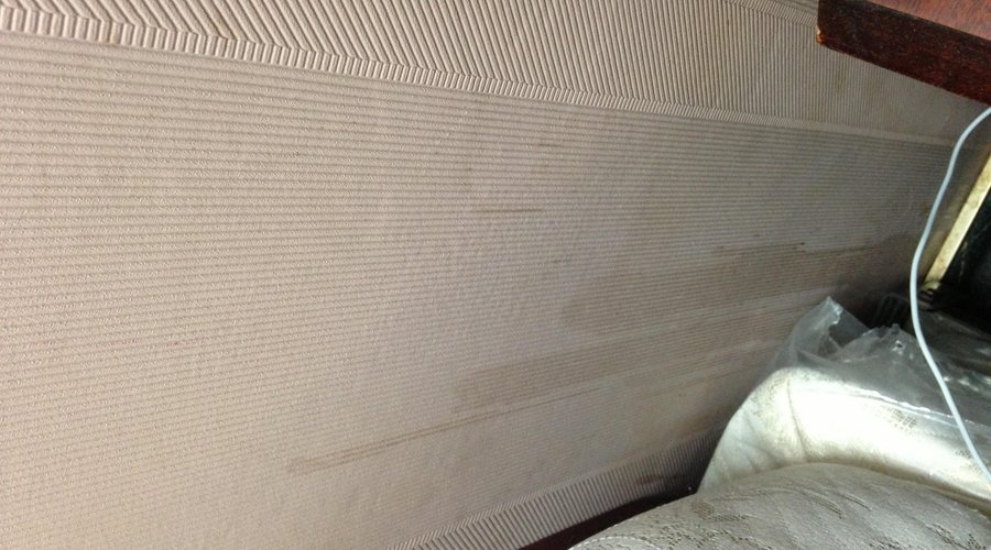 Stains on wall by head of bed