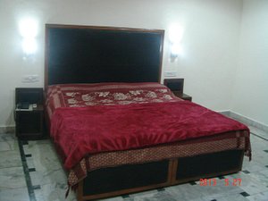 Hotel International in Jalandhar, image may contain: Furniture, Bed, Bedroom, Room
