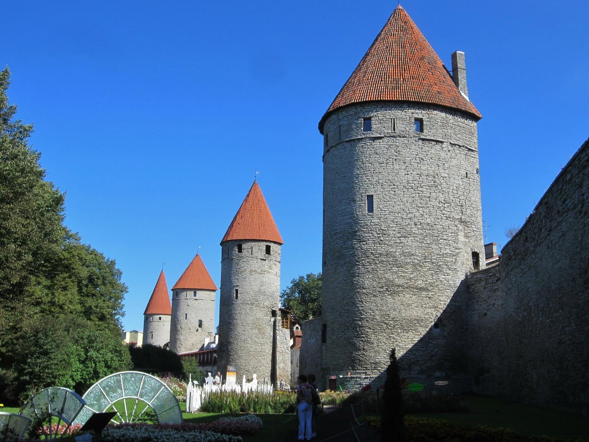 Visitors walking along the well-preserved medieval city walls of Tallinn, offering views over the historic Old Town.