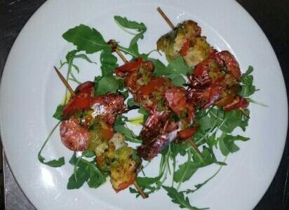 spiedini di pesce con rucola e salsa piccante.
