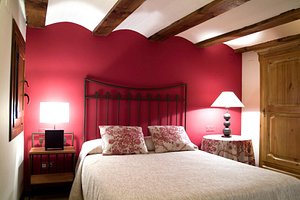 Hotel La Casa del Tio Americano in Albarracin, image may contain: Interior Design, Bed, Furniture, Lamp