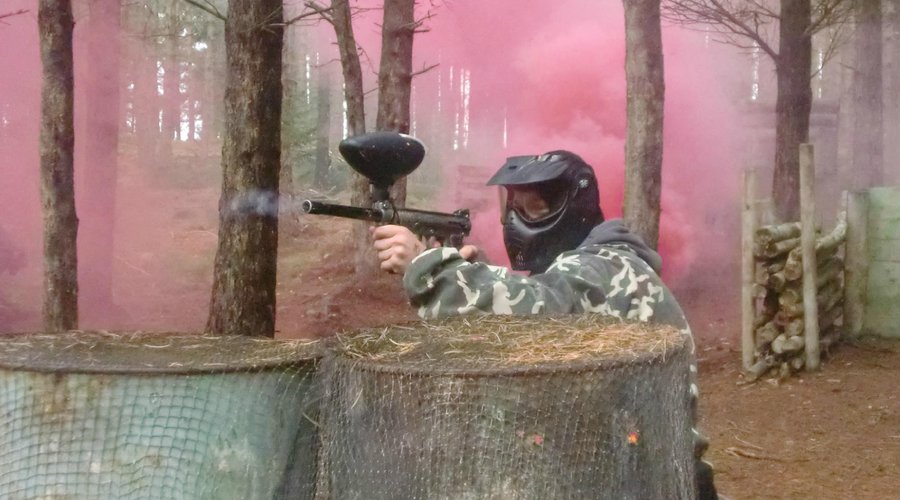 Returning fire from behind a set of metal drums.