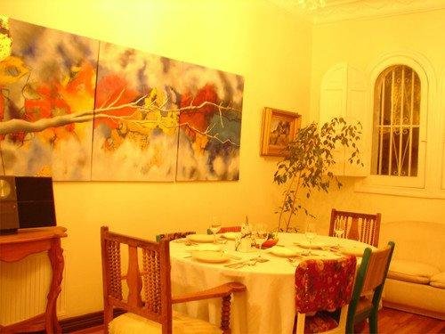 Parte del comedor, donde se pueden apreciar las pinturas del artista dueño del hotel