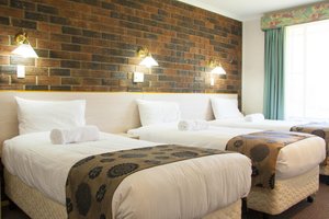 The Big Windmill Corporate & Family Motel in Coffs Harbour, image may contain: Furniture, Bedroom, Bed, Couch