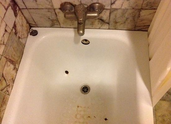 The bathtub is rusty and dirty and the water overflow is not at all connected to the tube. (seco
