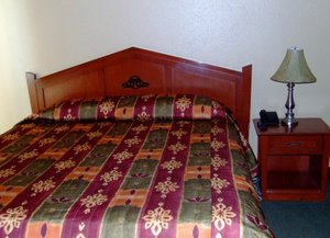 Yukon Inn in Whitehorse, image may contain: Lamp, Table Lamp, Bed, Furniture