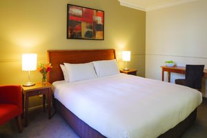 Distinction Palmerston North Hotel & Conference Centre in Palmerston North, image may contain: Bed, Furniture, Chair, Table Lamp