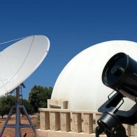 Il radiotelescopio e uno dei telescopi ottici, sullo sfondo della cupola del planetario.