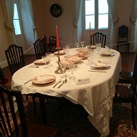Mesa de jantar com pratos de porcelana. Museu Campos