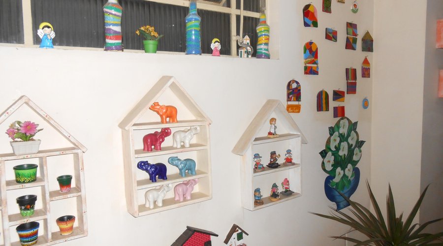 artesanatos de varios lugares enfeitam as paredes da pousada