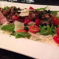 Tagliata sur lit de roquette et copeaux de parmesan