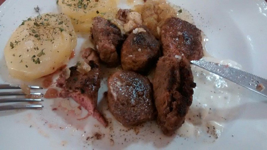 Solomillo acompañado de patatas al horno, cebolla confitada y salsa de queso