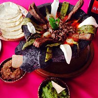 El molcajete. Hot stone bowl served with tender arrachera meat, panela cheese, nopal, onion and