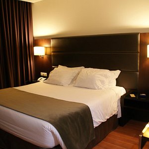 Axis Porto Business & Spa Hotel in Porto, image may contain: Bed, Furniture, Bedroom, Lamp