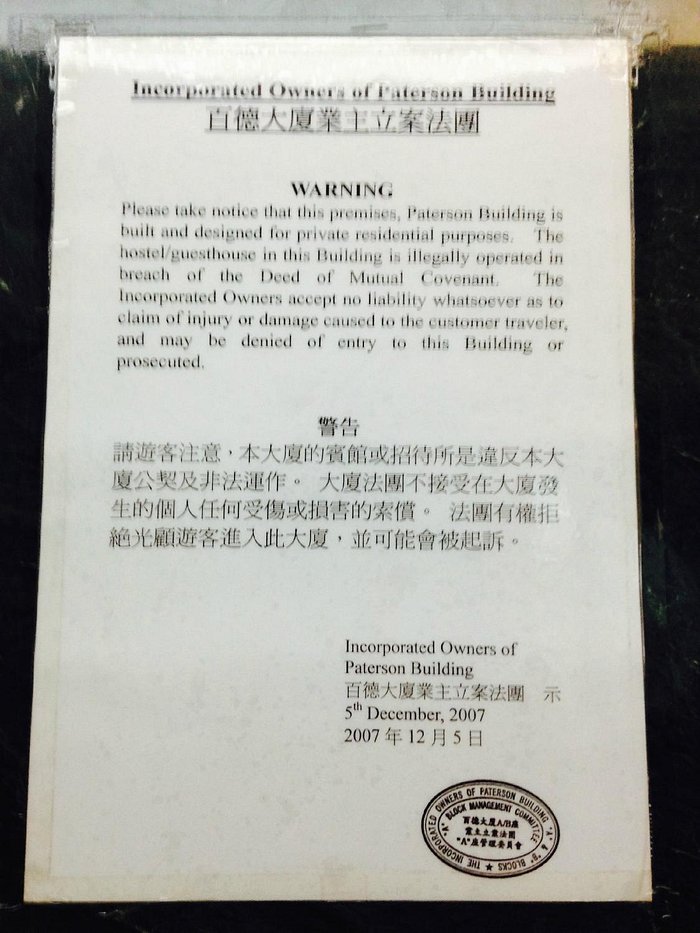 Notice of illegal operation of hostel in front of elevator on 1st floor.