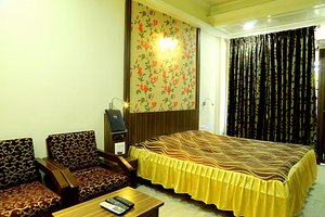 Hotel Shreyas in Pune, image may contain: Chair, Furniture, Remote Control, Bed