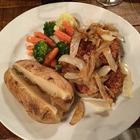Two fried pork chops with baked potato