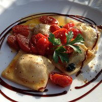 Home made ravioli with rucola and speck