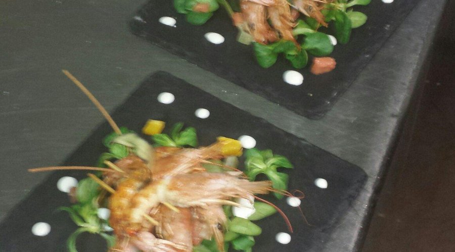Spiedino di gamberoni su insalata di songino e agrumi e panna acida