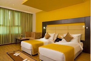 Poppys Hotel Madurai in Madurai, image may contain: Home Decor, Bed, Furniture