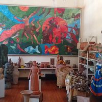 Sala com esculturas, telas, tudo muito bonito