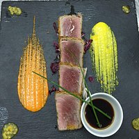 Tagliata di tonno rosso in crosta di pane aromatico, salsa di soia ed erba cipollina su letto di