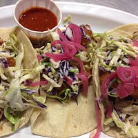 Grilled Shrimp tacos topped with cole slaw & pickled onion