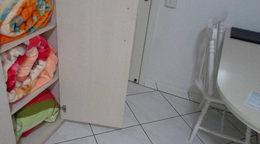 Frigobar, cobertas e mesa com cadeira