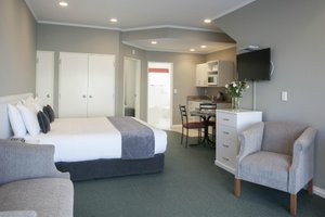 Cornwall Motor Lodge in Palmerston North, image may contain: Corner, Home Decor, Bed, Chair