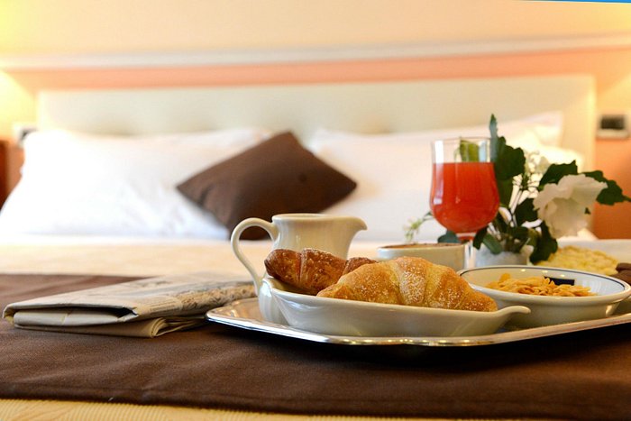 Un vassoio con colazione su un letto in una camera d'albergo Foto