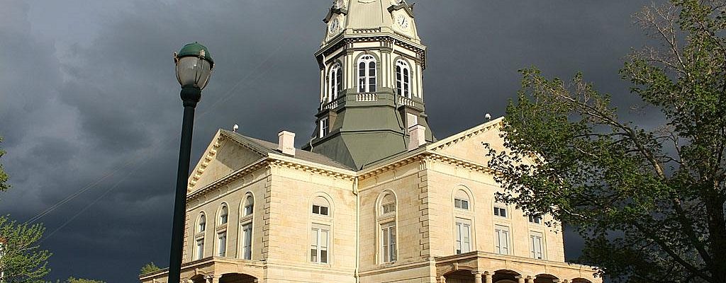 Madison County, Iowa Courthouse in bright sun with dark clouds behind it