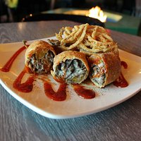 Cheese steak egg rolls stuffed with peppers, onions and mushrooms in a dish of sriracha ketchup!