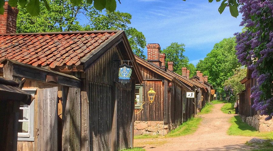 The LuostarinmĂ€ki Handicrafts Museum in Turku, Finland, showing a collection of traditional wooden houses with red roofs amidst lush greenery.