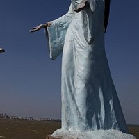 Estátua de Iemanjá e vista da praia com o Porto Tubarão ao fundo