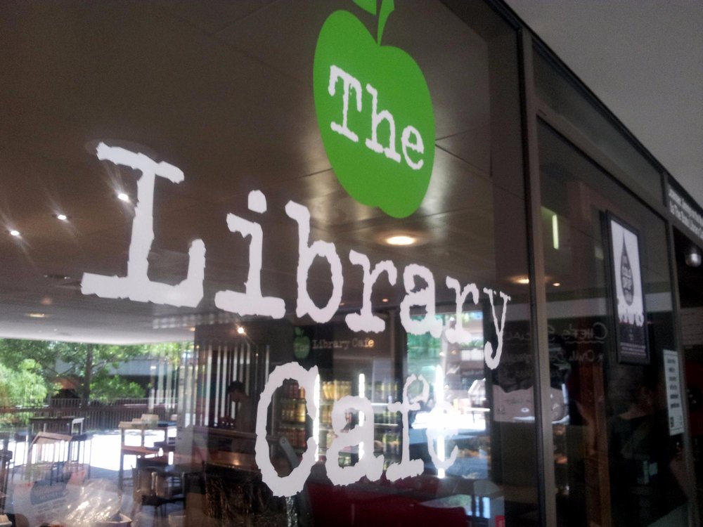 The lIbrary cafe logo on glass door