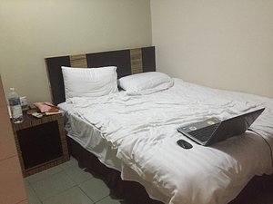 Hotel Traveller in Kota Kinabalu, image may contain: Furniture, Bed, Laptop, Bedroom