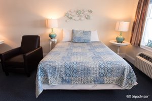 Atlantic Breeze Suites in Hampton, image may contain: Furniture, Bed, Lamp, Chair